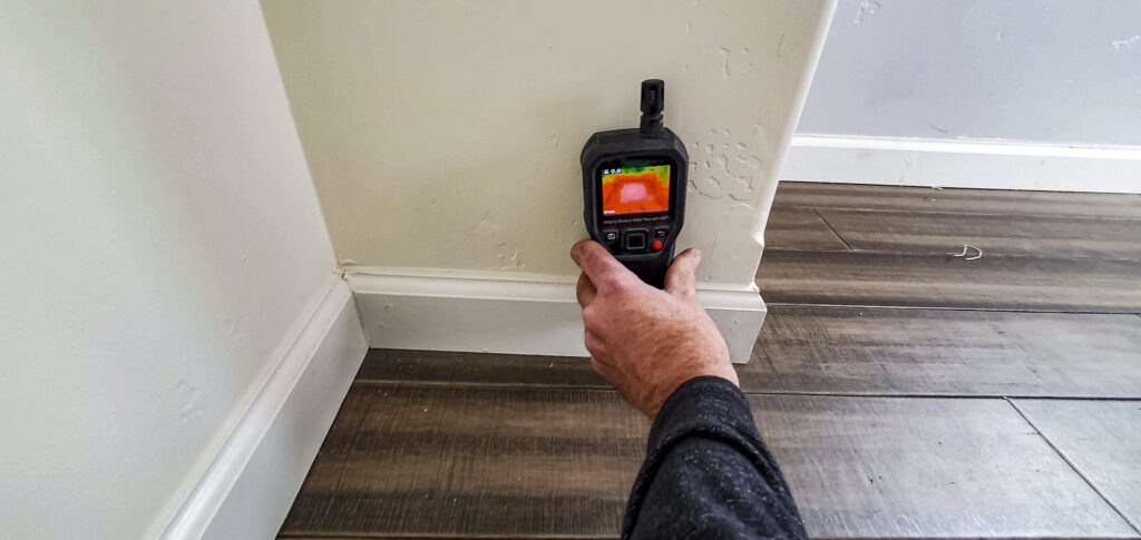 Water damage restoration technician checking moisture in a Chantilly home