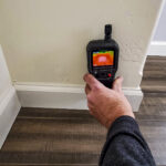 Water damage restoration technician checking moisture in a Chantilly home
