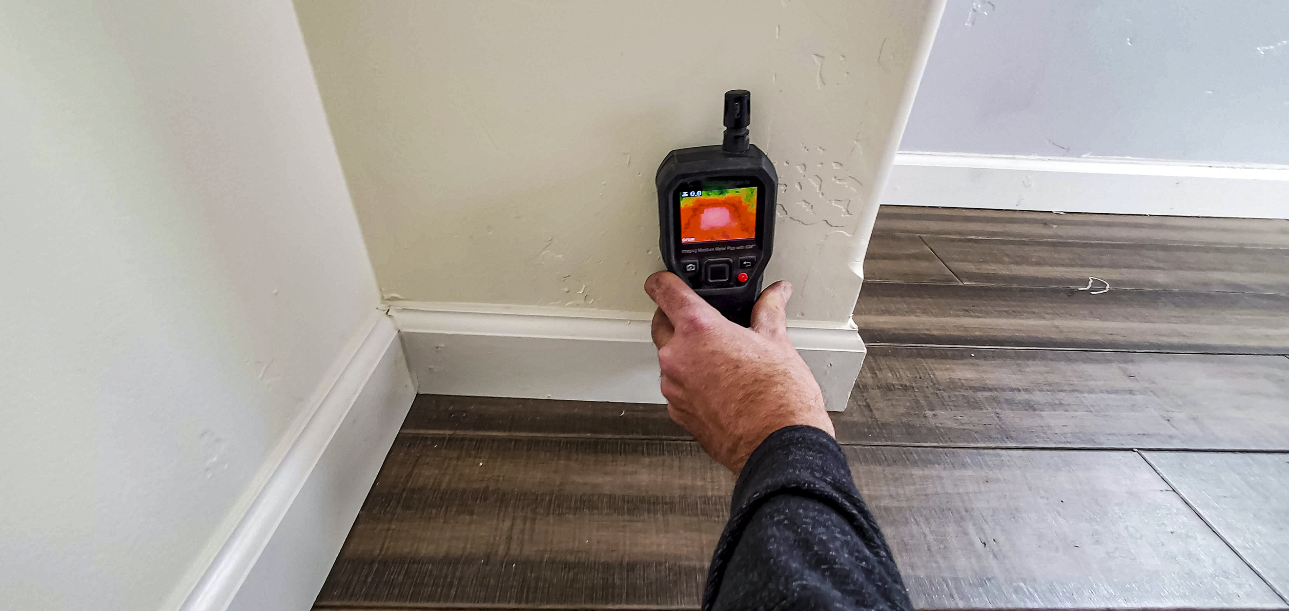 Water damage restoration technician checking moisture in a Chantilly home